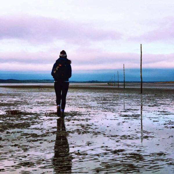 Person walking on the Pilgrims Way, Holy Island